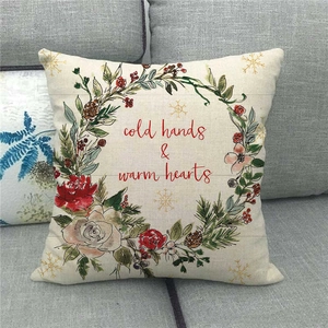 Detail of Christmas wreath pillowcase with Cold Hands Warm Hearts text on a sofa