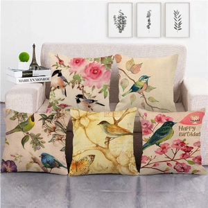 Set of five watercolor floral bird linen pillow covers on a cozy sofa setting