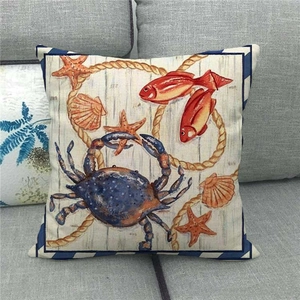 Nautical linen pillow cover featuring blue crab, starfish and sea fish on a grey sofa