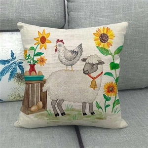 Close-up of linen pillowcase with farm animals and sunflowers on a gray sofa