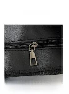 Close-up of smooth metal zipper and premium leather texture on large black tote bag