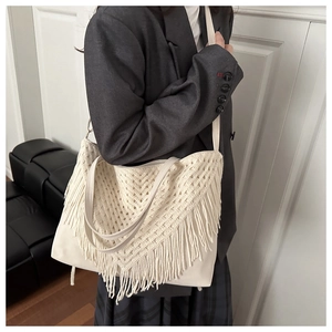 Detail of bohemian cream woven tote bag featuring layered crochet and long fringes