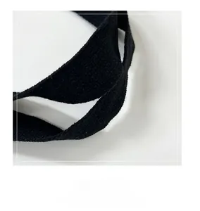 Detailed close-up of double-stitched black cotton handles on a quilted tote bag