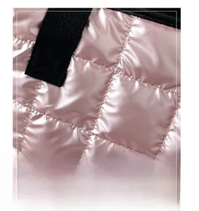 Macro shot of pink glossy quilted fabric with metallic finish and black woven strap detail