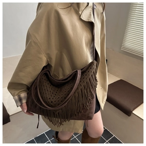 Detailed close-up of dark brown bohemian fringed tote bag with crochet hollow out weaving