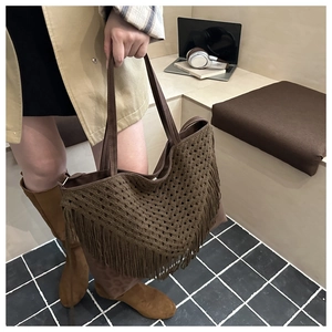 Detail view of dark coffee crochet tote bag with long fringes and leather handle