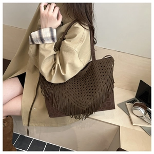 Detail of dark brown knit tote with V-pattern crochet, fringe, and leopard print base