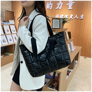 Close-up of black quilted space cotton tote bag with fluffy puffer texture on model