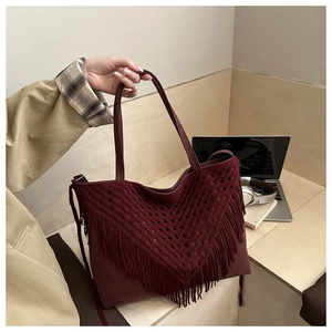 Detail of burgundy crochet tote bag showing bohemian long fringe and knit mesh texture