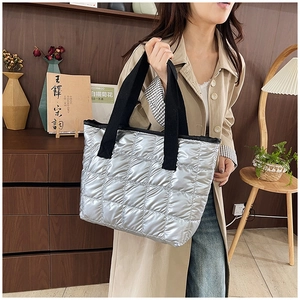 Close-up of silver quilted tote bag featuring metallic gloss and large capacity design