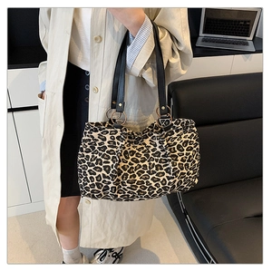 Close-up of leopard print tote bag with black leather straps and gold metal rings