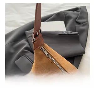 Macro detail of brown suede leather texture and smooth silver metal zipper on bag
