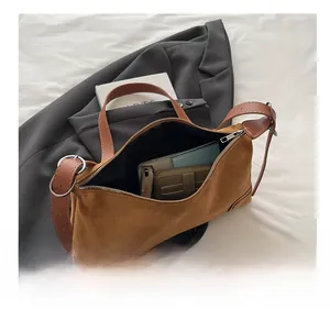 Macro view of brown suede shoulder bag showing spacious interior and vintage stitching
