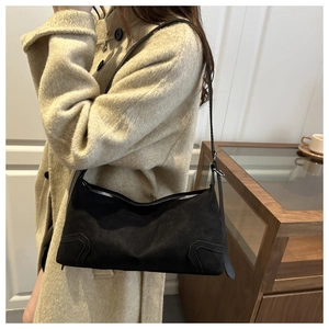 Detail of black matte suede shoulder bag with silver zipper and reinforced corner design
