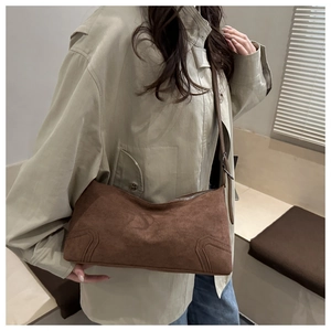 Detail view of brown matte underarm bag with decorative stitching and silver metal zipper