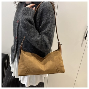 Detail of vintage brown suede underarm bag showing textured finish and fine stitching