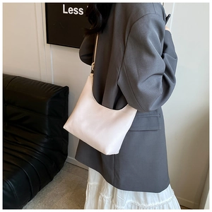 Close-up of white hobo bag with lychee grain texture shown on a female model's shoulder