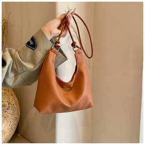 Close-up of caramel retro PU leather tote bag with lychee texture and slim strap