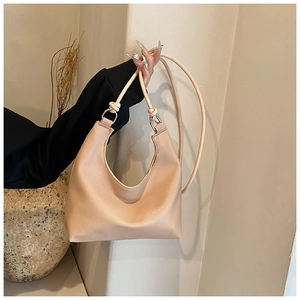 Detail of hobo bag handle with silver ring hardware and knot decor on lychee leather