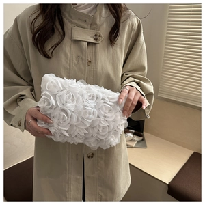 Detail of elegant white clutch bag with 3D mesh rose petals for wedding or party