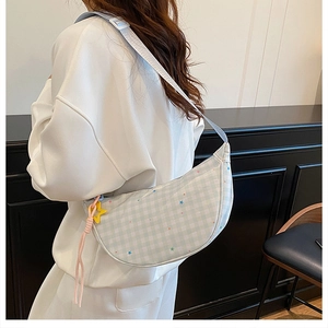 Détail du sac croissant à carreaux vert clair avec pendentif étoile jaune et motifs