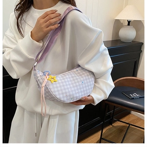 Detail of purple plaid crescent bag featuring a yellow star charm and woven pink cord