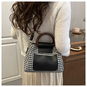 Détail du sac cabas à motif pied-de-poule avec poignée en bois et bandoulière en cuir