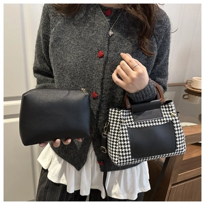 Detail of houndstooth tote bag with wooden handle and matching black leather pouch