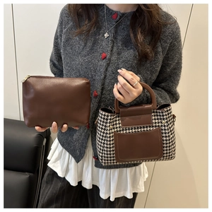 Detailed set of brown leather clutch and plaid handbag held by a model in casual outfit