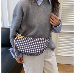 Détail du sac demi-lune à carreaux avec pendentif étoile et corde rose sur mannequin