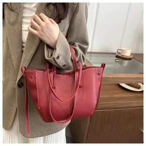 Macro view of red lychee textured tote bag with white contrast stitching details