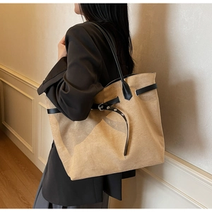 Detail of khaki suede tote bag featuring black leather belt accent and metal buckle