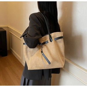 Close-up of contrast leather belt buckle on large khaki minimalist tote bag with soft texture