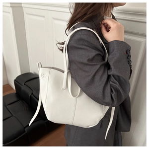 Gros plan d'un sac cabas blanc avec texture litchi et détails gaufrés sur le côté
