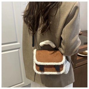 Dettaglio della borsa a spalla in pelle scamosciata marrone con finiture in sherpa bianco