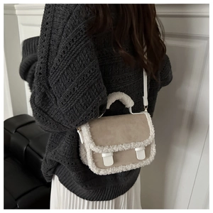 Detail of plush suede crossbody bag with fleece trim worn by a model in autumn outfit
