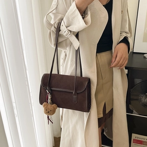 Large dark brown suede shoulder bag with a cute plush bear pendant shown on model