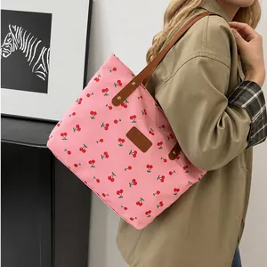 Nahaufnahme der rosa Canvas-Einkaufstasche mit Kirschmuster und braunen Ledergriffen