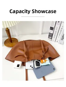 Brown leather tote bag showing large capacity with tablet, phone, and accessories inside