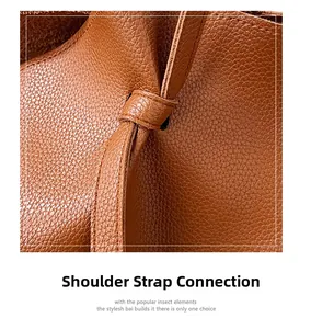 Detail shot of brown lychee leather shoulder bag with knotted strap attachment
