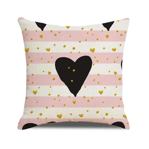 Close-up of linen pillowcase with pink stripes, gold hearts, and black heart print