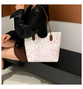 Close-up of stylish white tote bag featuring pink graffiti patterns and slim brown straps