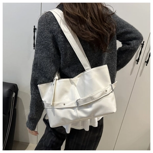 Detailed back view of a white leather tote bag with stylish buckle strap and dual handles