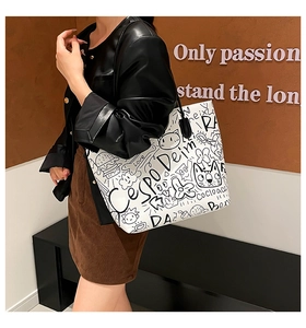 Detailed close-up of a white tote bag with black graffiti illustrations on leather texture
