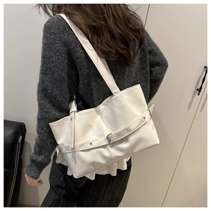 Detail view of white PU leather tote bag featuring stylish belt buckle with metal eyelets