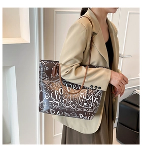 Vista dettagliata della borsa tote marrone con illustrazioni graffiti e spalline lunghe