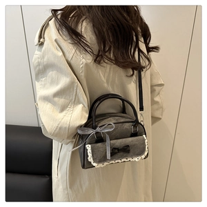 Model wearing dark grey denim bowling bag with lace trim and check bow detail