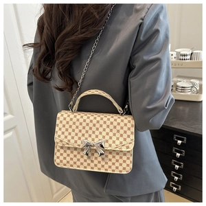 Détail d'un mini sac carré vintage avec boucle nœud argentée et bandoulière chaîne