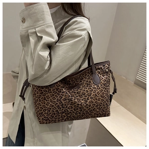 Détail d'un sac cabas à motif léopard avec poignées en cuir et cordon de serrage