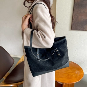 Détails d'un sac cabas noir matelassé avec finitions mates et rivets dorés chics